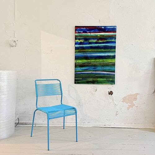 Farbenfrohes abstraktes Gemälde mit horizontalen Linien in Blau, Grün und Rot, an einer weißen Wand in einem Atelier.