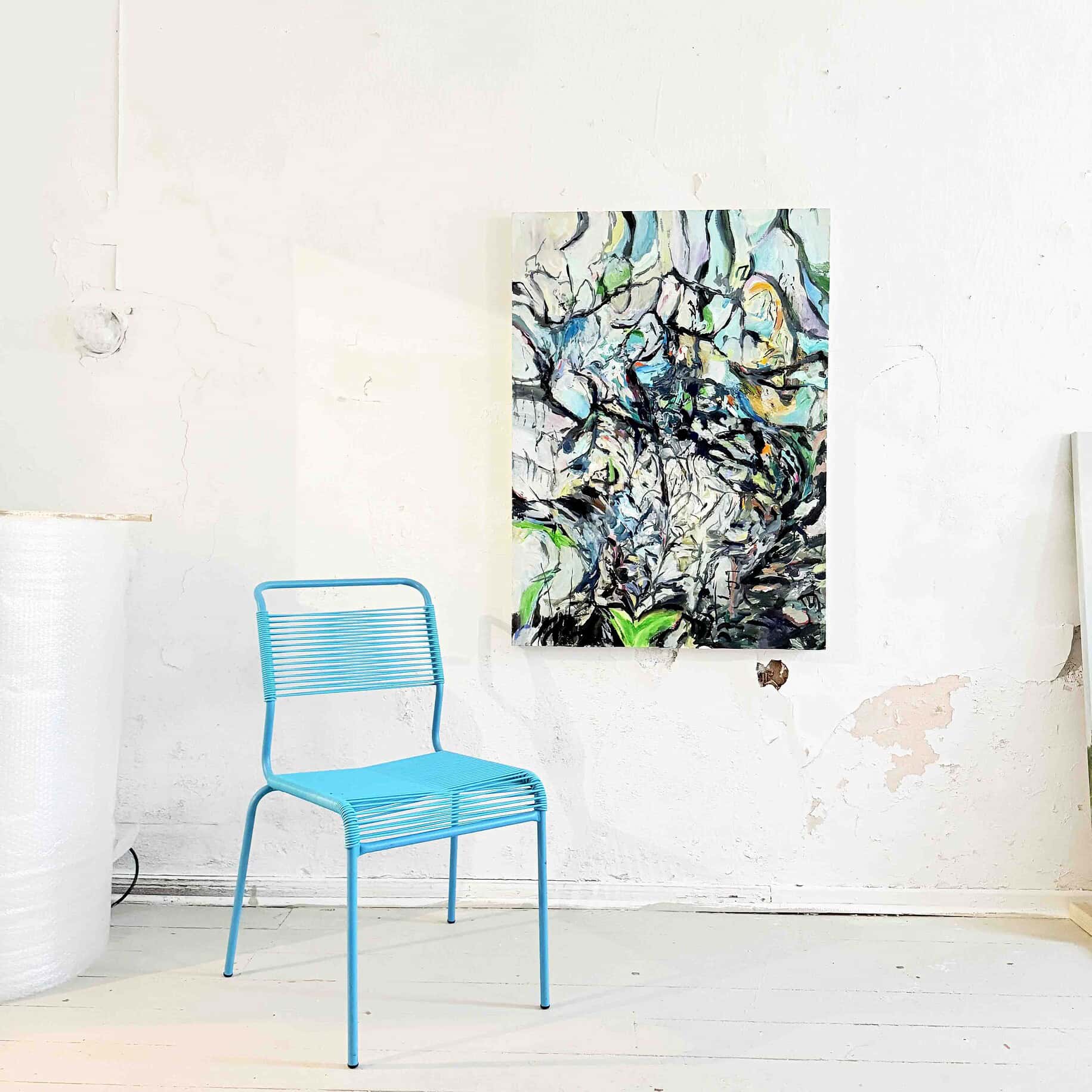 Farbenfrohe abstrakte Acrylmalerei an weißer Wand, moderne Kunstwerke im Atelier von Nikolaus Kriese, kreative Künstlermalerei, lebendige Farbkompositionen, professionell gestaltete Auftragskunst.