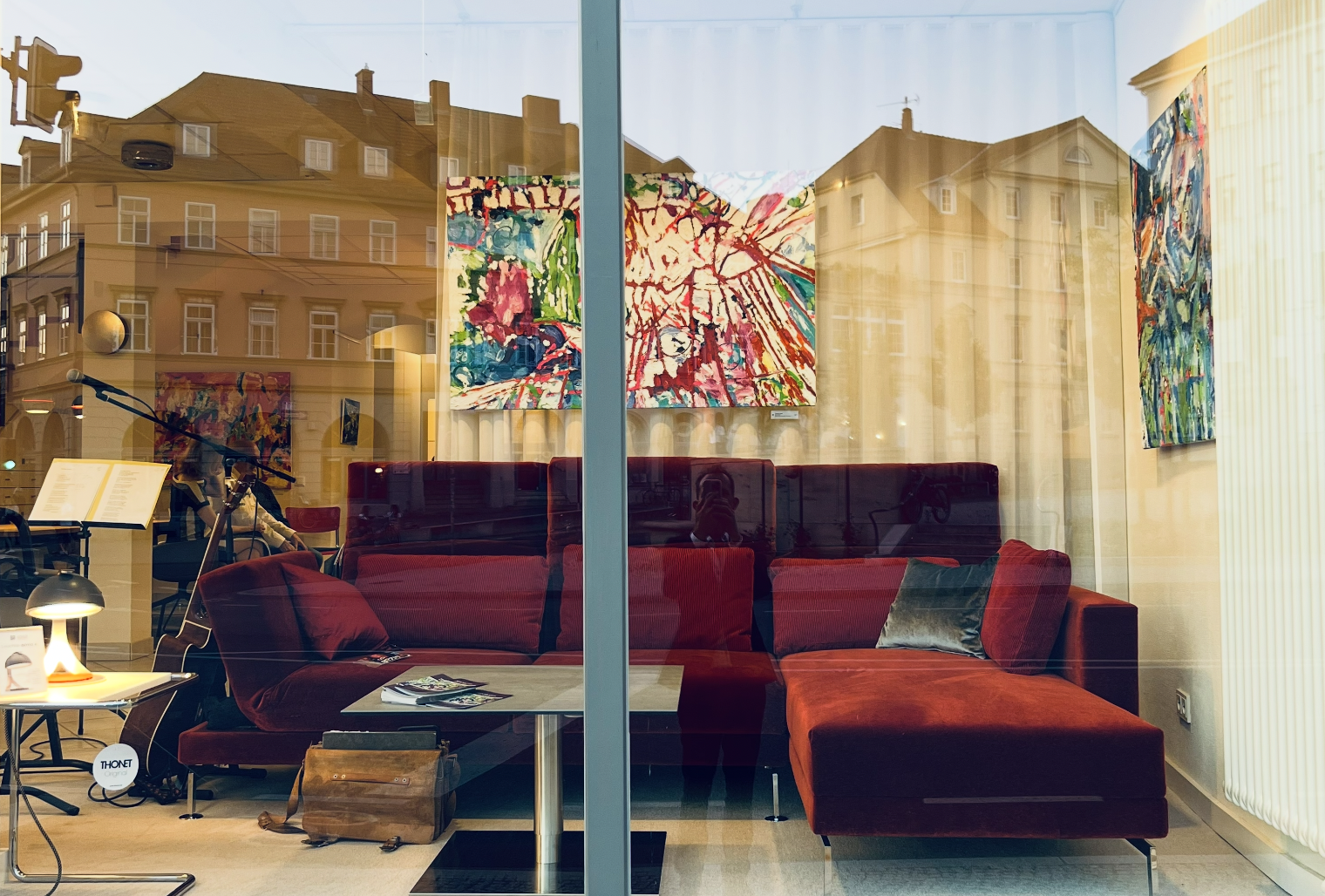 Farbenfrohe abstrakte Malereien in einer Kunstgalerie, moderne Auftragskunst, kreative Acrylbilder, lebendige Kunstwerke, zeitgenössische Malerei im Schaufenster.