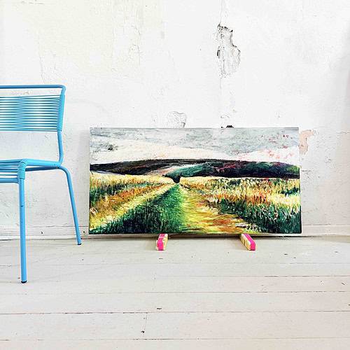 Leinwand mit impressionistischem Landschaftsmotiv, auf dem Boden vor einer weißen Wand mit Rissen und Abplatzungen.