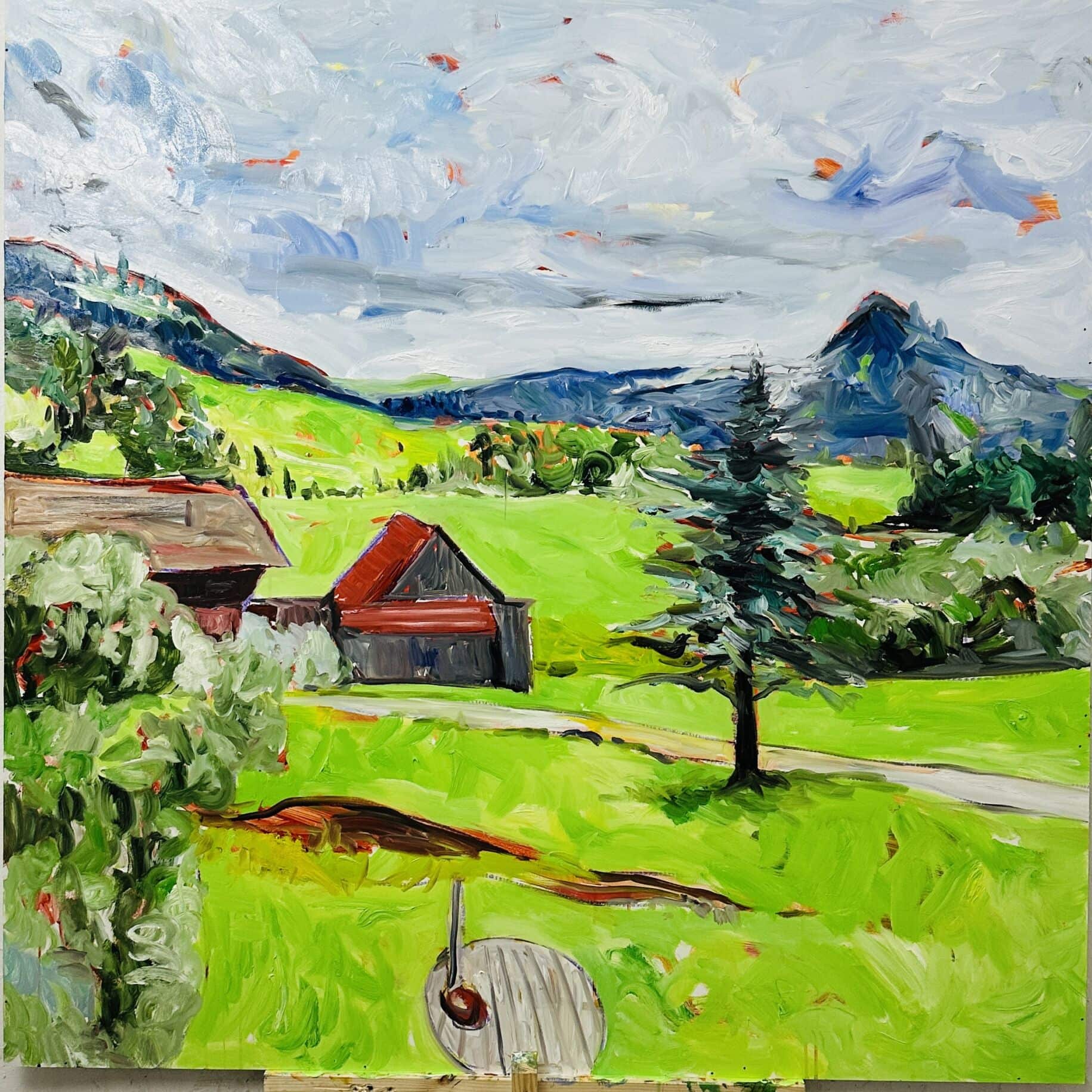 Farbenfrohes Ölgemälde einer ländlichen Szenerie mit grünen Hügeln, Schuppen und Berg im Hintergrund, typisch für die Malerei und Auftragsmalerei von Nikolaus Kriese, lebhaft und impressionistisch gestaltet.