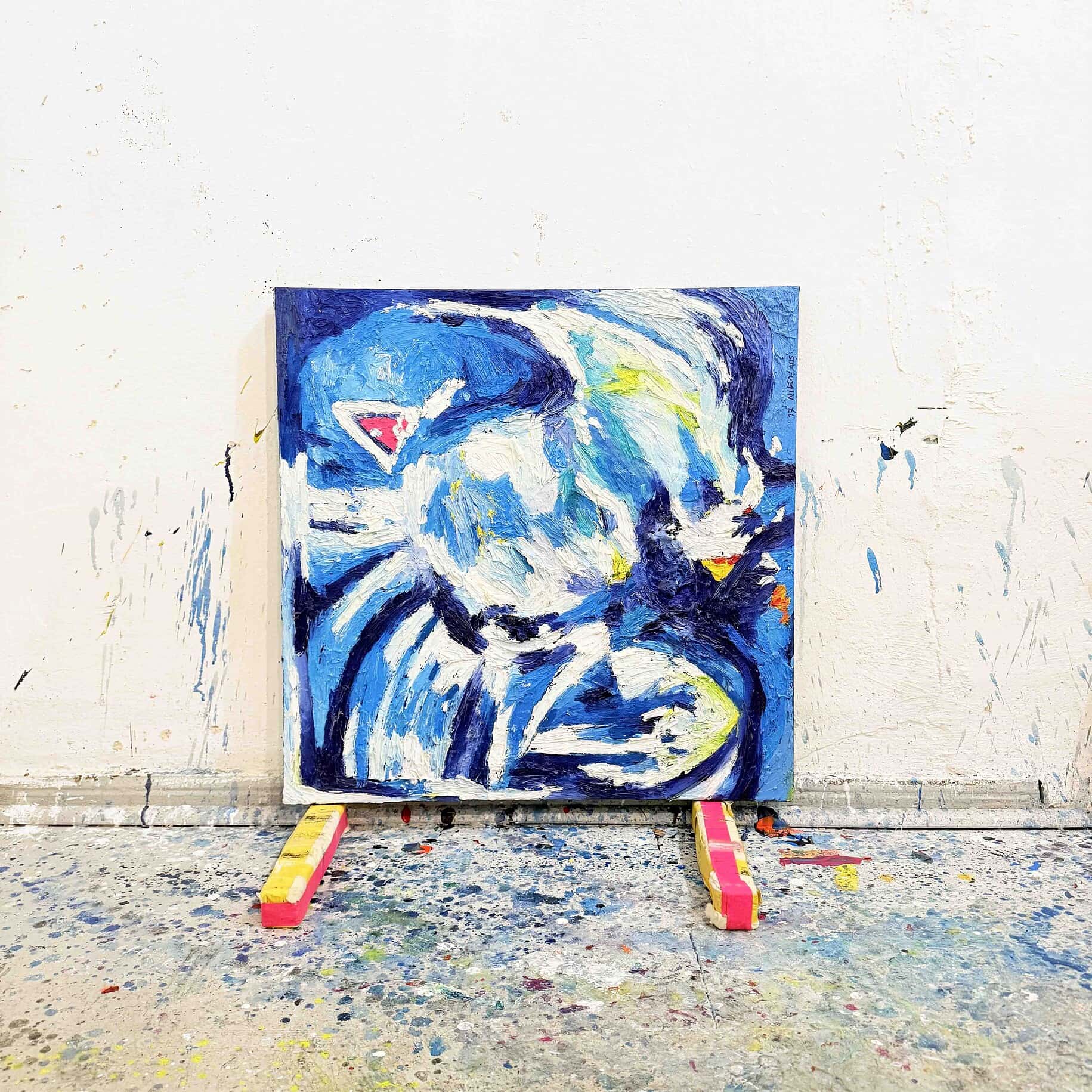 Lebendige abstrakte Tiermalerei eines Tigers in Blau, Weiß und Gelb, auf Canvas gemalt, präsentiert auf einer Staffelei im Künstleratelier. Ein modernes Kunstwerk, das Dynamik und Ausdruckskraft vermittelt.