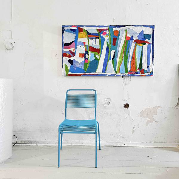 Lebendige abstrakte Malerei mit bunten Formen und Linien, hängt an einer weißen Wand in einem Kunststudio ebenso like einer blauen Metall-Stuhl.