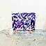 Lebendige abstrakte Acrylmalerei in Violett-, Blau- und Weißtönen auf Leinwand, präsentiert auf einer Staffelei in einem Kunstatelier.