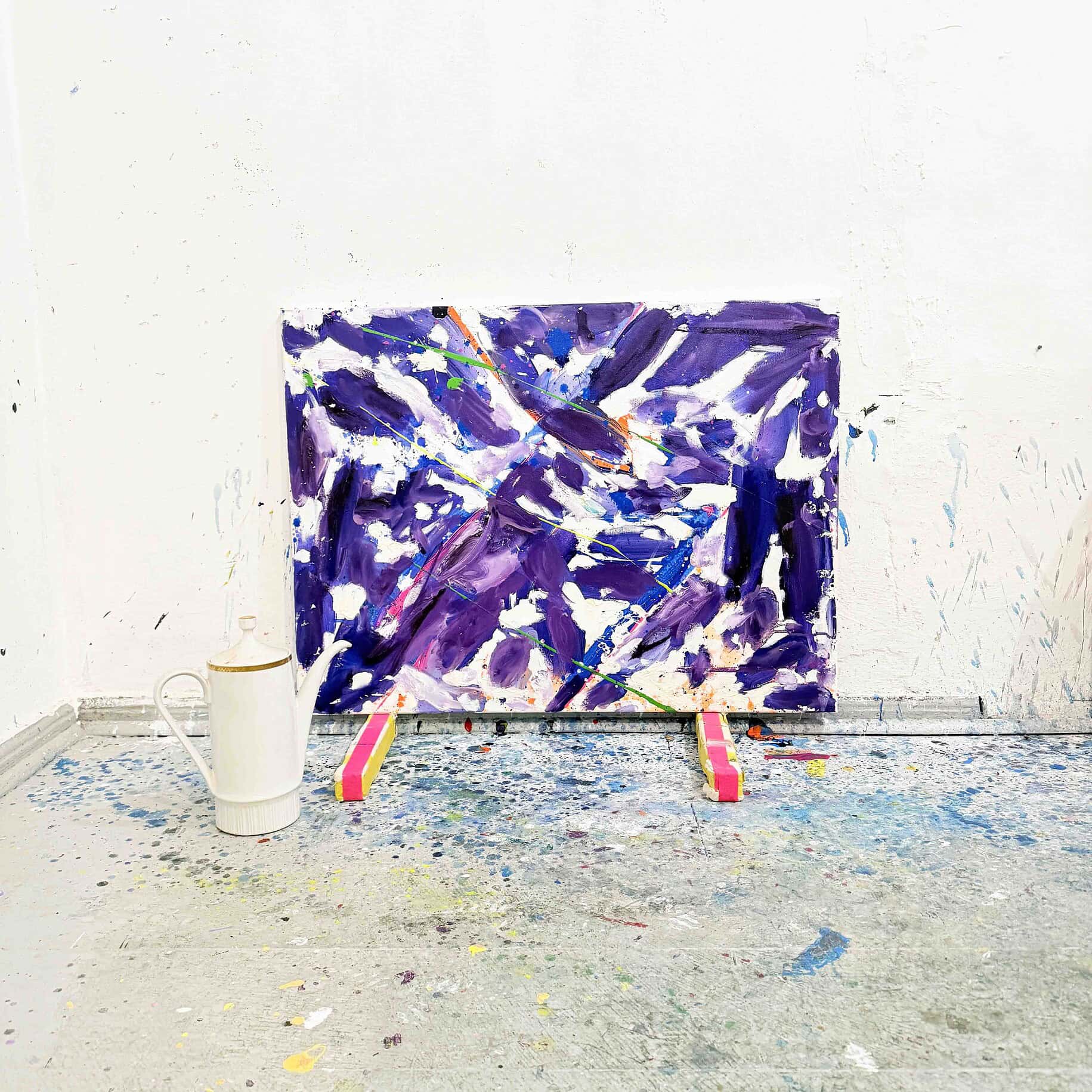 Lebendige abstrakte Acrylmalerei in Violett-, Blau- und Weißtönen auf Leinwand, präsentiert auf einer Staffelei in einem Kunstatelier.