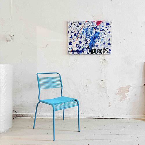 Leere blaue Stuhl vor veralteter, weißer Wand mit moderner abstrakter Malerei von Nikolaus Kriese.