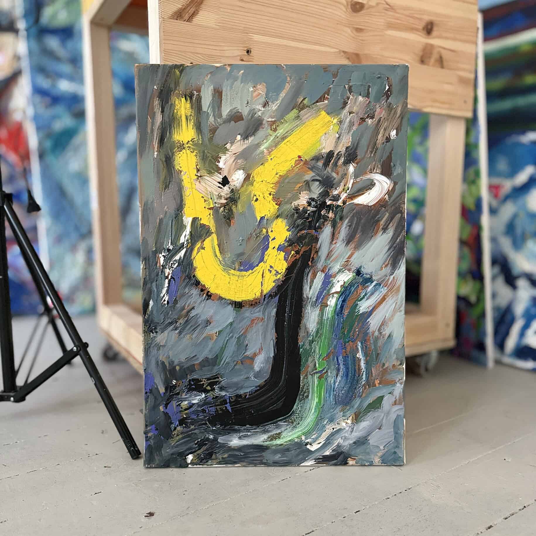 Farbenfrohes abstraktes Gemälde mit kräftigen Pinselstrichen und einer gelben Form, in einem künstlerischen Malatelier, das kreative Kunstwerke zeigt.