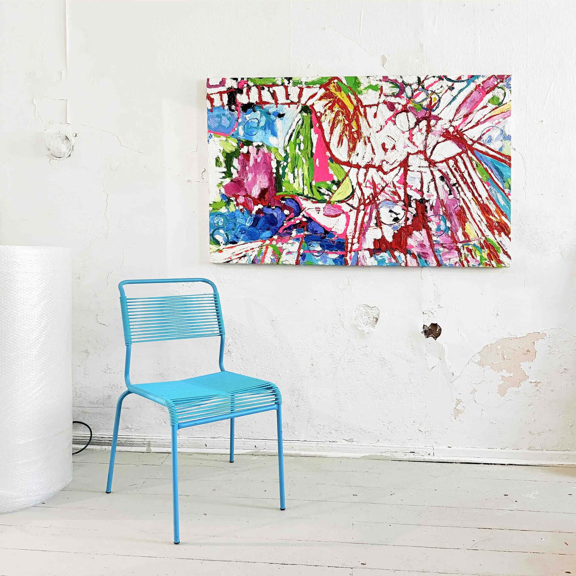 Farbiges abstraktes Gemälde an einer weißen Wand, daneben eine blaue Metallstuhl, kreative Kunstgalerie, moderne Malerei, original Kunst, farbenfrohe Kunstwerke, zeitgenössische Kunstkunstwerk, bunte Malerei, inside art exhibition.