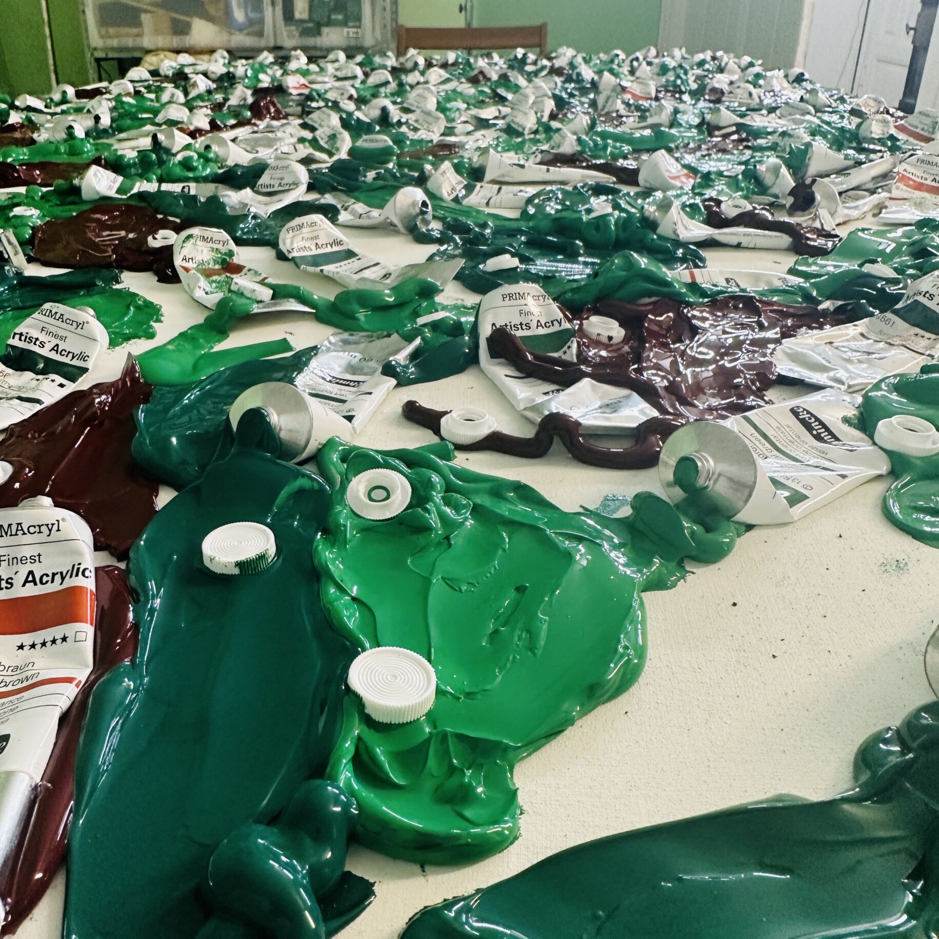 Gedruckte Acrylfarben und Tuben auf Malertisch, Kunstmalerei, Auftragsmalerei, Künstlerbedarf, kreative Farbpalette, emotionale Kunst, moderne Malerei, professionelle Künstlermaterialien, farbintensive Kunstwerke, individuelle Kunstaufträge.