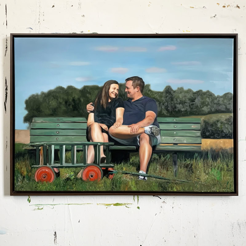 Maßgeschneiderte Auftragsmalerei eines lachenden Paares auf einer Parkbank, realistische Maltechnik, personalisiertes Portrait, kreativer Kunstauftrag, hochwertige Ölfarbe, individuelle Wandbildgestaltung.