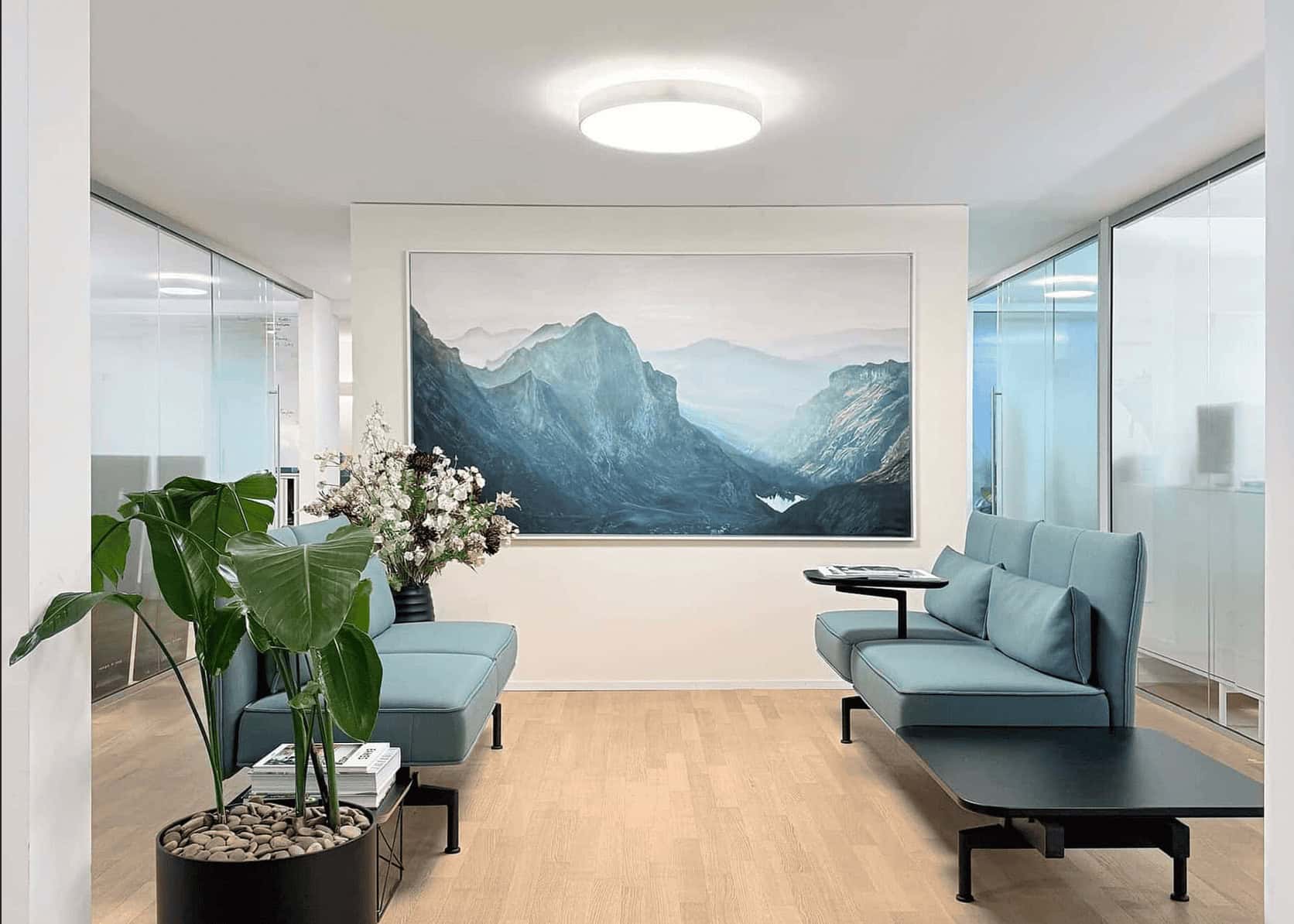 Auftragsmalerei - Bild malen lassen Zeitgenössische Auftragsmalerei Berglandschaft in einem modernen Büro, umgeben von eleganten Sitzmöbeln und Pflanzen, die eine ruhige und inspirierende Atmosphäre schaffen.